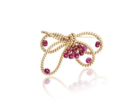  A RUBY AND GOLD BOW BROOCHThe double-loop bow of rope twist design, highlighted with oval-shaped ruby cabochons, mounted in 