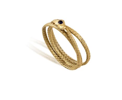 A GOLD AND SAPPHIRE 'SERPENT' BANGLE, CIRCA 1910The highly articulated sprung wrap-around bracelet designed as a serpent with