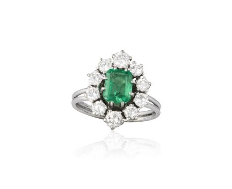 AN EMERALD AND DIAMOND CLUSTER RINGThe rectangular-cut emerald, weighing approximately 1.20cts, within a round brilliant-cut 