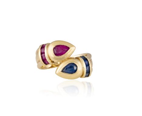 A SAPPHIRE AND RUBY RINGOf crossover design, each shoulder set with a pear-shaped ruby and sapphire, each highlighted by cali