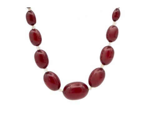 A cherry amber bakelite and paste bead necklace. Twenty-two bakelite beads spaced with faceted clear paste beads, length 16",