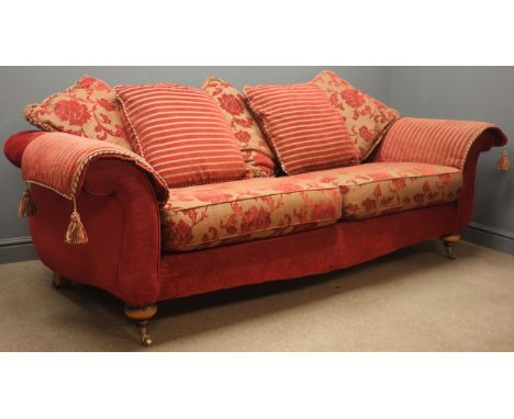 Three seat traditional shaped sofa, upholstered in red and gold floral fabric with striped scatter cushions, turned walnut fi