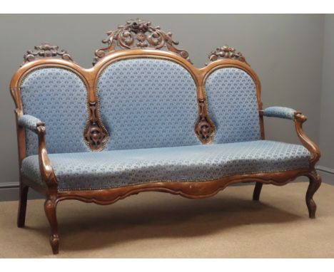 Victorian upholstered walnut sofa, triple arched cresting rail with ornate carved scrolling foliage pediments, shaped apron o