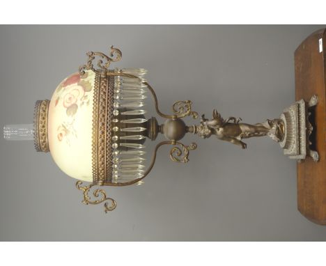 Victorian style cast metal figural oil lamp, three scrolling supports, floral decorated opaque glass shade with drops and cle