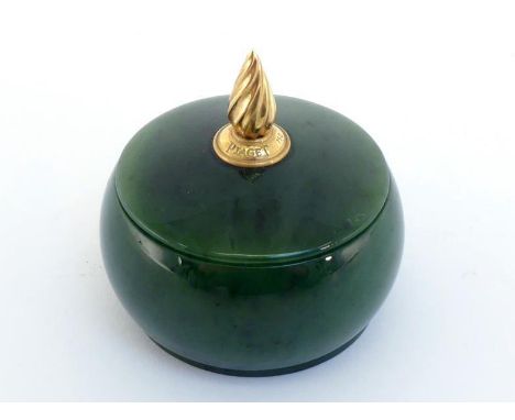 A nephrite covered pot with gold flame finial stamped "PIAGET", 5 cm. diameter, 6 cm. high.In good condition. 