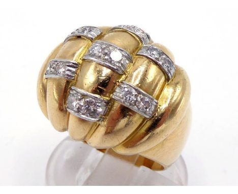 A French 18 carat gold and diamond bombe dress ring, the high domed and fluted bezel with pairs of  brilliants and smaller ei