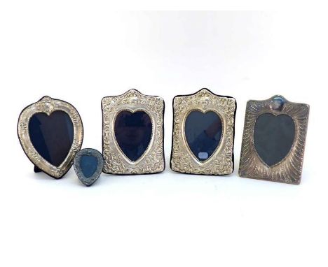 A group of four modern silver-faced photograph frames and another smaller, three rectangular with heart-shaped apertures, one