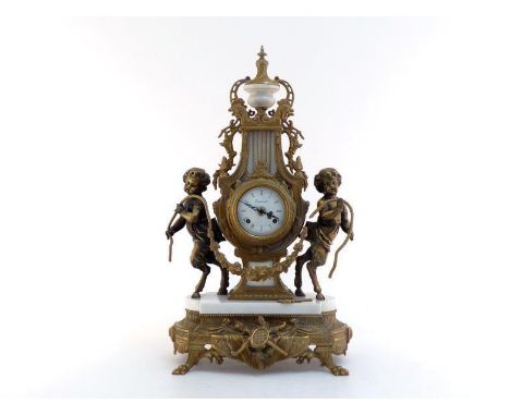 A large mantel clock in the French Empire style, the lyre-shaped ormolu case with marble urn and ormolu finial, flanked by tw