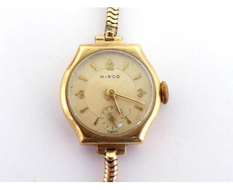 A lady's 9 carat gold wristwatch, the textured circular dial with gilt markers and hands, 21mm diameter, with 15 jewel manual