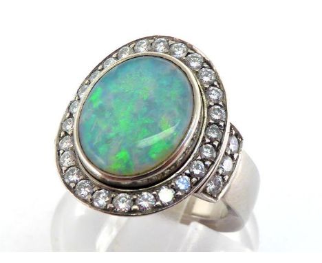 A precious opal and diamond cluster ring, the central oval opal cabochon 12 x 9.5mm, in a surround of small brilliants, to br