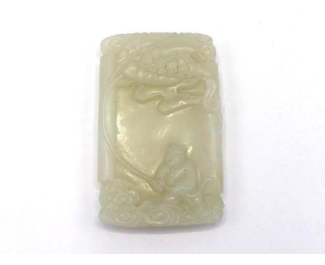 A Chinese carved white jade plaque of rectangular form, finely decorated in relief with a child playing a dragon Kate in the 