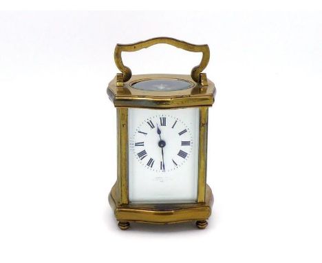 A shaped gilt brass cased carriage clock with enamel face, oval movement view panel, steel platform. In good clean working or