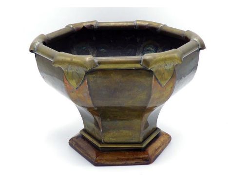 A sturdy Arts and Crafts copper and brass small jardiniere, the shaped hexagonal brass panelled planter with tapering copper 