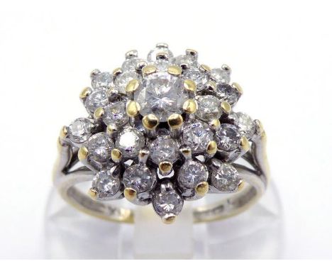 An 18 carat gold and diamond cluster ring, the tiered cluster centring on a 0.16 carat brilliant, the shank fully hallmarked,