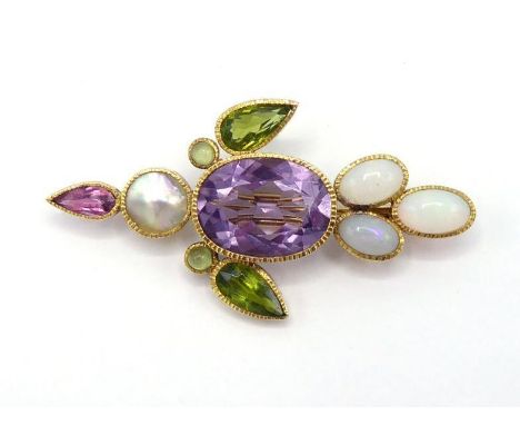 A multi gem brooch, composed of a rub over set oval cut amethyst to the centre, in a surround of peridot, mother of pearl, rh