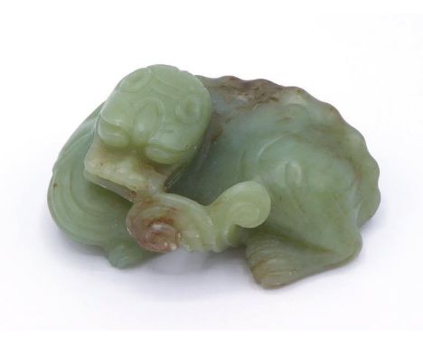 A Chinese carved yellow jade ornament of a recumbent Kylin, mouth holding a branch of Lingzhi, stone in yellow celadon tone w