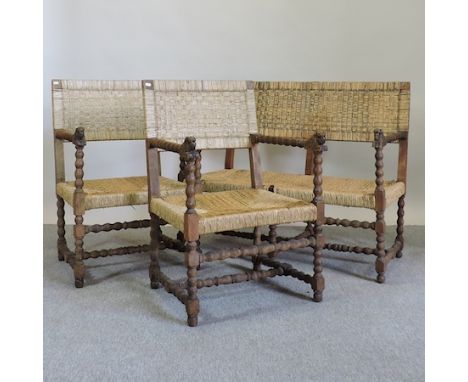 A carved oak and rush seated three piece suite, comprising of a bench and two armchairs, each carved with animal faces