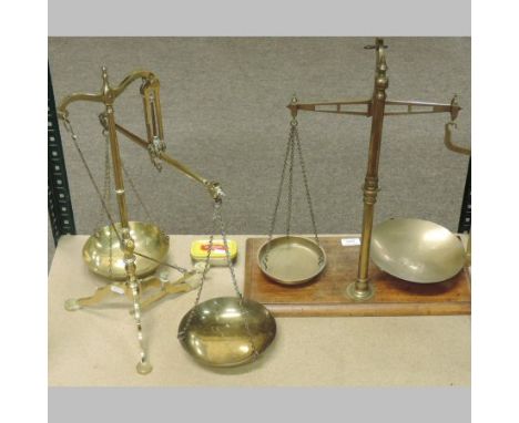 A pair of brass balance scales, by Doyle & Sons, 55cm tall, together with another set