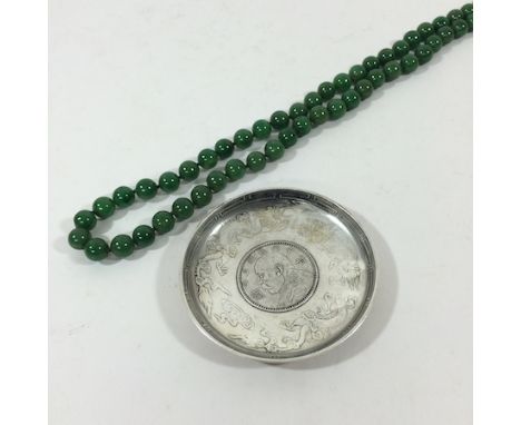 A jade coloured bead necklace, together with a white metal coin dish