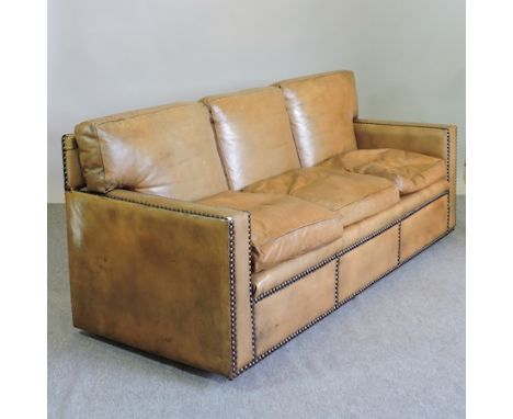 A brown leather upholstered and studded three seater sofa, 201cm