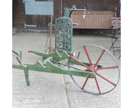 A set of green painted wrought iron grain scales, Bartlett & Son, Bristol, 120cm tall, together with a green painted wheelbar