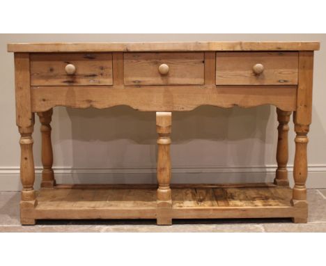 A Victorian style pine dresser, late 20th century, the plate rack with a moulded cornice over a shaped frieze and two open sh