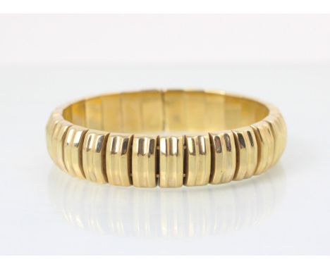 A 9ct yellow gold bangle, the rectangular panelled bangle with faceted design, hidden box and tongue fastening with import ma