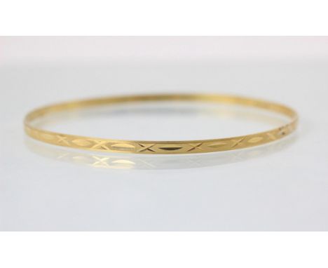 A yellow metal bangle, with cross and dash engraved detail, 7.3cm wide, stamped '750' 6gms
