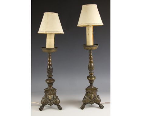 A pair of 19th century brass lamp bases, each with turned columns and raised on triangular shaped bases, cast with cherubs ma