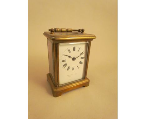 An early 20th century French brass carriage clock with white enamel face, Roman numerals, with key   