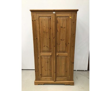 Modern pine dwarf double wardrobe with two panelled doors enclosing hanging rail on plinth base with bracket feet H164, W92.5