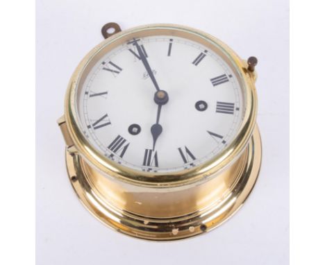 Chutz, a brass cased ships bulk head clock with key, diameter 15cm.