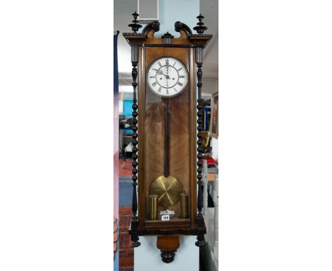 A Vienna type walnut and mahogany cased wall clock, with train movement, swan neck pediment, bobbin turned supports, with two