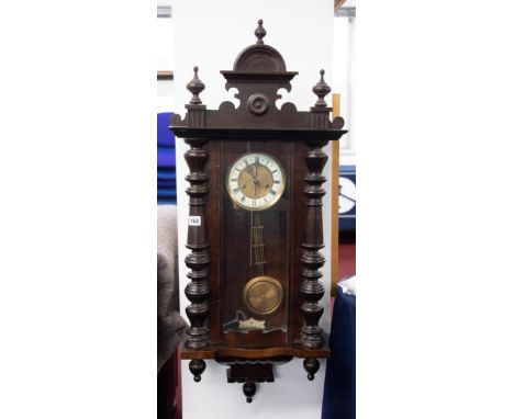 A Victorian mahogany cased wall clock with carved pediment and pendulum.