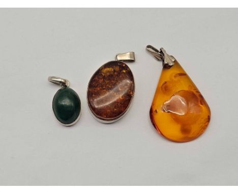 Two silver mounted amber pendant and one other