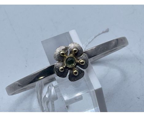 A silver and gold peridot torque bangle