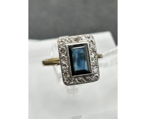A RECTANGULAR SAPPHIRE AND DIAMOND CLUSTER RING 18CT GOLD AND PLATINUM THE CENTRAL SAPPHIRE IS NATURAL AND UNHEATED SIZE L