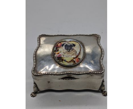 A silver jewellery box mounted with an enamel portrait of a pug dog, raised on 4 paw feet, indistinct British hallmark, maker
