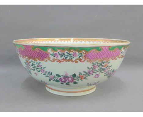 Chinese famille rose porcelain punch bowl painted with flowers and foliage with a pink scale and gilt edged rim on a circular