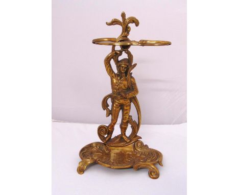 A brass umbrella and stick stand in the form of a male figure on shaped oval base with scroll supports, 58 x 36cm