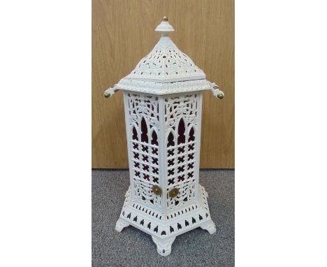 A Victorian white cast iron Cathedral heater of pierced octagonal form with two carrying handles, the hinged doors open to re