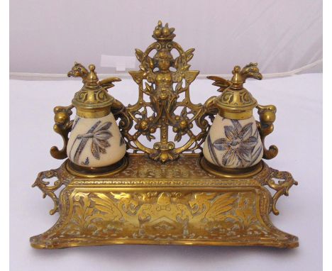 A Victorian shaped rectangular brass and ceramic desk stand, scroll pierced and chased with masks and mythological beasts, th