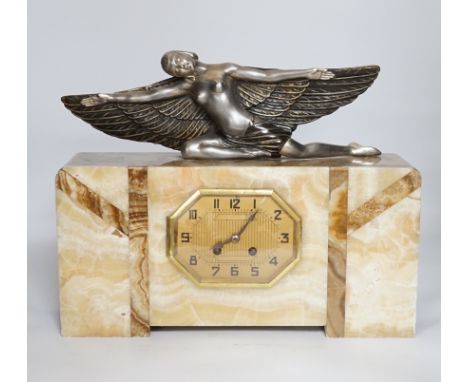 An Art Deco marble mantel clock with a metal winged woman, with French pendulum movement striking on a bell, 38cm wide, 30cm 