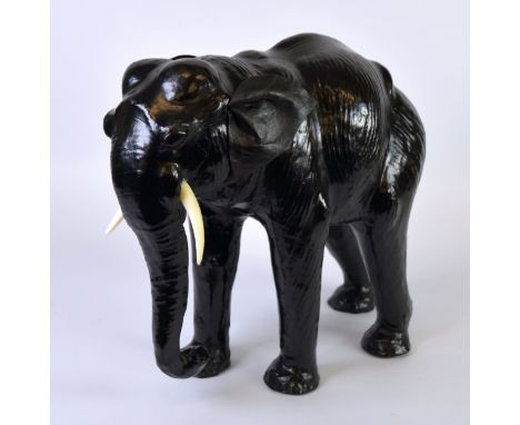 LIBERTY’S STYLE MODERN BLACK LEATHER COVERED MODEL OF AN ELEPHANT, with trunk down, flapping ears and white plastic tusks, 14