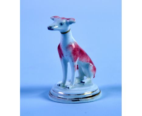MID NINETEENTH CENTURY ENGLISH PORCLEAIN MODEL OF A SEATED DOG, with brown splashed and gilt collar, on a gilt lined, circula