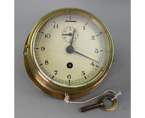 A brass cased bulkhead style wall timepiece, first half 20th century, the 5" enamel dial with Arabic numerals, 17cm diameter,