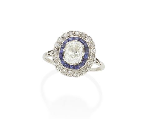 DIAMOND AND SAPPHIRE CLUSTER RING, EARLY 20TH CENTURYThe central cushion-shaped diamond, weighing 1.65 carats, within borders