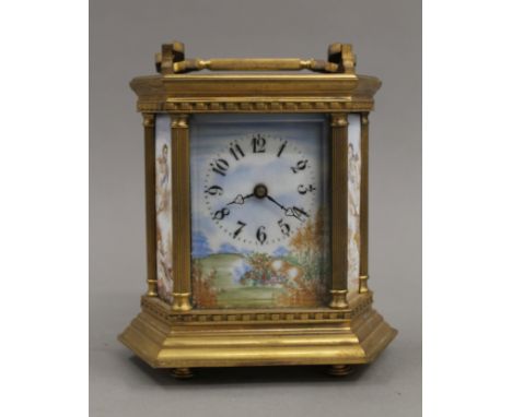 A brass cased carriage clock set with enamel panels. 17 cm high.