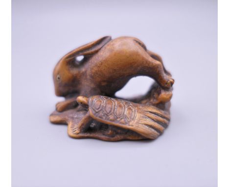 A Japanese hare and tortoise wooden netsuke. 4 cm long.