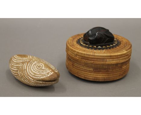 An Indonesian woven circular box the lid inlaid with mother-of-pearl and mounted with wooden fish, and a Papua New Guinea amu